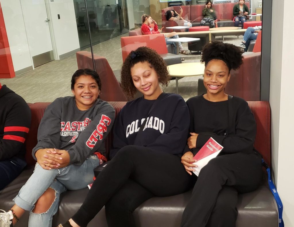 students sitting on couch together smiling